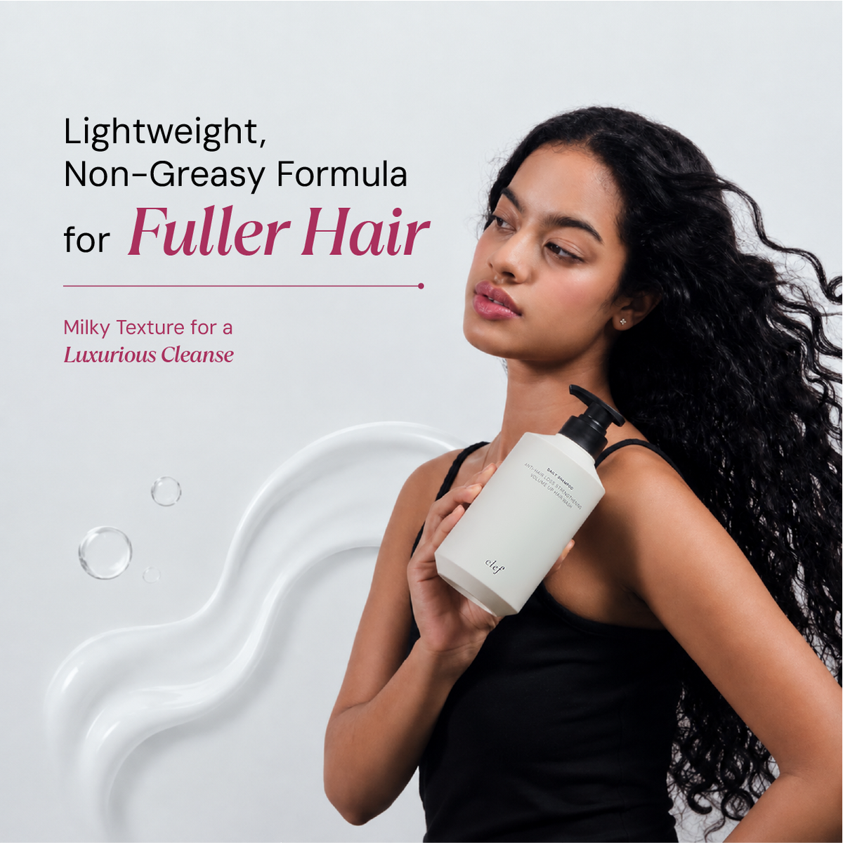 A woman with long, curly dark hair holds a white pump bottle against a light gray background with promotional text about a lightweight, non-greasy formula for fuller hair.